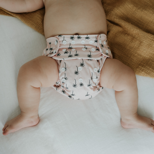 baby in a pale pink cloth nappy