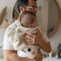Adult holding baby wearing reusable nappy