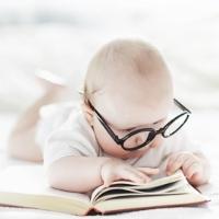 Baby wearing glasses and reading a book